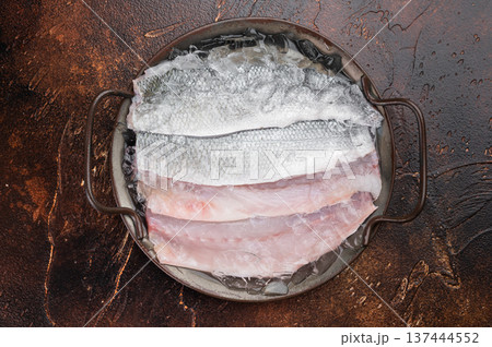 Top view of raw sea bass seabass fillets with thyme on rustic metal tray, clean culinary composition showing freshness, protein rich Mediterranean cuisine. 137444552