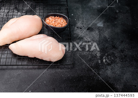 Fresh chicken breasts, beautifully displayed, showcasing their tender texture. Perfect for marinating and cooking your favorite dishes. black background. top view Fresh chicken breasts, beautifully displayed, showcasing their tender texture. Perfect for marinating and cooking your favorite dishes. black background. top view 137444593