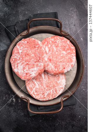 Frozen Meat cutlet, mincemeat of pork and beef for burgers. black background. top view Frozen Meat cutlet, mincemeat of pork and beef for burgers. black background. top view 137444607