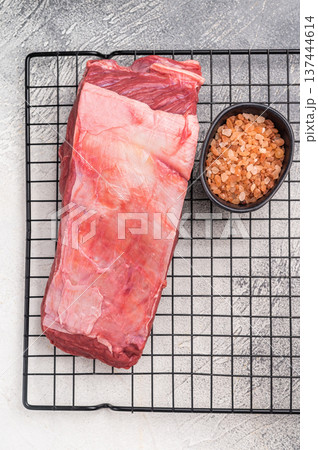 Close-up of raw buffalo meat cuts, highlighting the marbling and vibrant hue, perfect for creating delicious and nutritious dishes. grey background. top view Close-up of raw buffalo meat cuts, highlighting the marbling and vibrant hue, perfect for creating delicious and nutritious dishes. grey background. top view 137444614