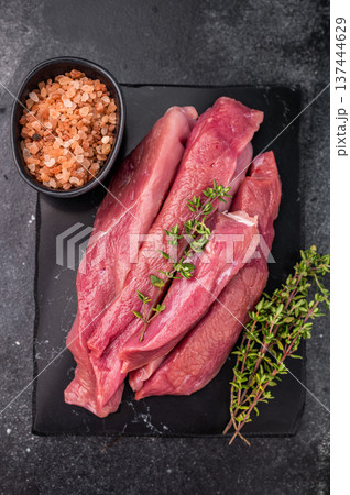 Raw sliced duck breast fillet, uncooked poultry meat. black background. top view Raw sliced duck breast fillet, uncooked poultry meat. black background. top view 137444629