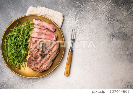 Roasted BBQ pork neck meat steak on plate with salad. grey background. top view Roasted BBQ pork neck meat steak on plate with salad. grey background. top view 137444662