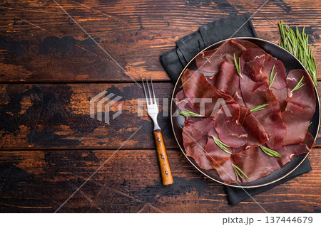 Spanish tapa Cecina meat slices, beef jamon on plate with herbs. wooden background. top view 137444679