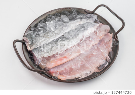 Uncooked European sea bass fillets chilled on ice with herbs, premium raw seafood ingredient ideal for menu design, nutrition and recipe background. Uncooked European sea bass fillets chilled on ice with herbs, premium raw seafood ingredient ideal for menu design, nutrition and recipe background. 137444720