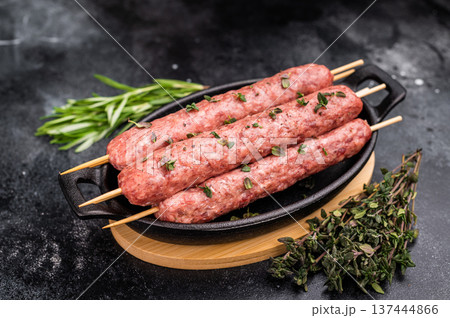 Raw shish kebab, arabic kofta kofte kebab from mince lamb and beef meat on Skewer. black background. top view 137444866