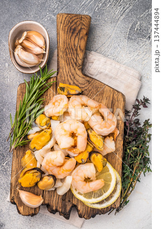 Fresh Seafood cocktail, raw Mix with Mussels, Clams, Prawns, Shrimps and squid on wooden board. white background. top view 137444894