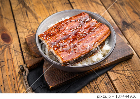 Unagi don or Japanese grilled eel rice in a bowl. wooden background. top view Unagi don or Japanese grilled eel rice in a bowl. wooden background. top view 137444916
