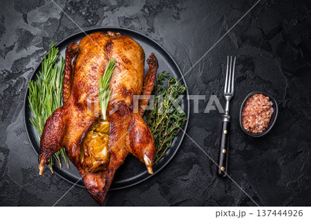 Grilled duck with apples on plate with herbs. black background. top view 137444926