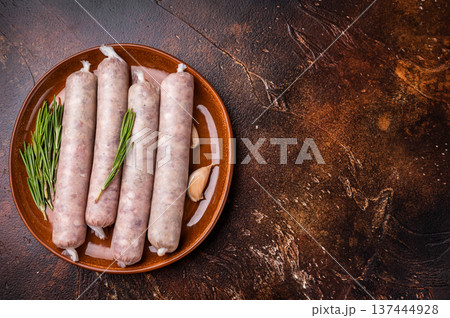 Raw Sausages with forcemeat mincemeat with herbs in plate. brown background. top view Raw Sausages with forcemeat mincemeat with herbs in plate. brown background. top view 137444928