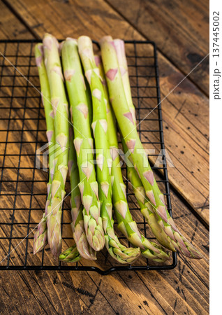 Green asparagus stems close up on grill rack, seasonal organic vegetable background ideal for cooking, healthy diet and farm themes. 137445002