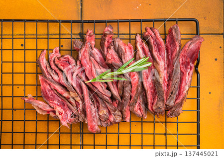 Grilled bavette flap steak sliced medium rare arranged on cooling rack with rosemary herbs over bright orange textured background overhead gourmet barbecue composition with copy space Grilled bavette flap steak sliced medium rare arranged on cooling rack with rosemary herbs over bright orange textured background overhead gourmet barbecue composition with copy space 137445021