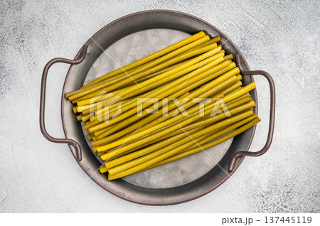 Fresh Fermented ramsons stems arranged in metal pan on light background. Wild garlic ingredient, foraged spring greens, minimal rustic food concept.. Fresh Fermented ramsons stems arranged in metal pan on light background. Wild garlic ingredient, foraged spring greens, minimal rustic food concept.. 137445119