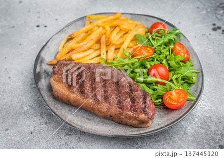 Juicy grilled beef culotte steak with potatoes and arugula salad, sirloin cap cut served for lunch or dinner 137445120