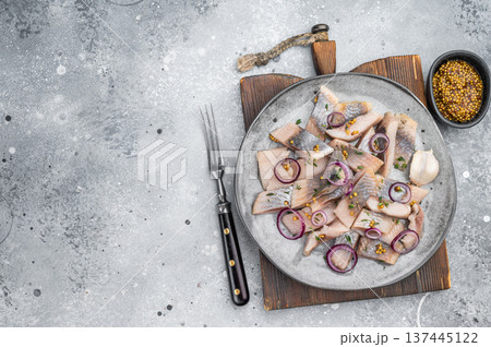 Pickled sardine chunks cured in salt and brine served with onion herbs and garlic. Traditional seafood appetizer on light background. 137445122