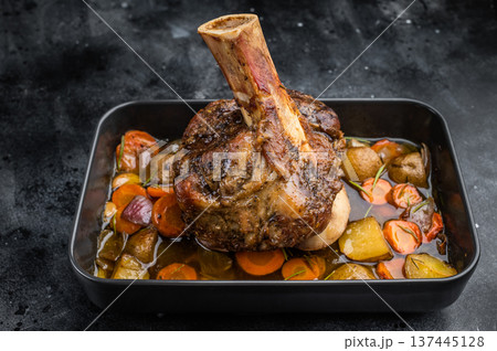 Slow roasted veal shank ossobuco with bone marrow vegetables and rich gravy in baking dish top view 137445128
