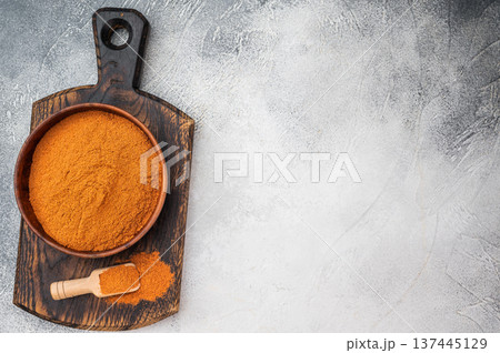 Fine ground paprika powder used for cooking and seasoning. Natural spice texture on wooden board with copy space Fine ground paprika powder used for cooking and seasoning. Natural spice texture on wooden board with copy space 137445129
