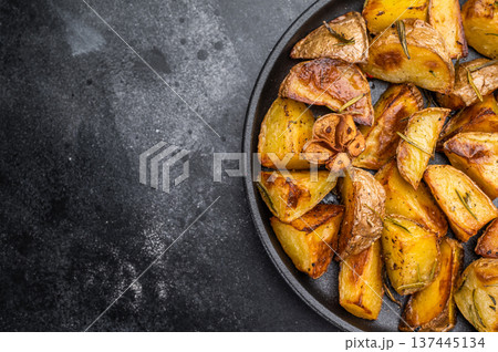 Crispy potatoes with skin seasoned with rosemary and garlic in pan. Homemade comfort food overhead view Crispy potatoes with skin seasoned with rosemary and garlic in pan. Homemade comfort food overhead view 137445134