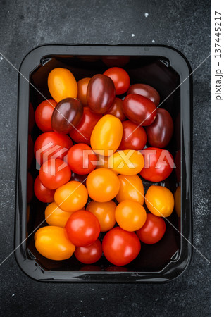 Fresh organic cherry tomatoes arranged in a retail style container clean minimal top view great for healthy cooking and salad concepts. Fresh organic cherry tomatoes arranged in a retail style container clean minimal top view great for healthy cooking and salad concepts. 137445217
