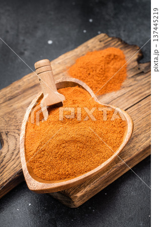 Paprika spice powder with rich orange red color in heart bowl. Aromatic seasoning ingredient flatlay with copy space 137445219