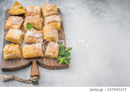 Traditional Greek filo custard pastry also known as milk pie cut into portions rustic wooden board top view Traditional Greek filo custard pastry also known as milk pie cut into portions rustic wooden board top view 137445257