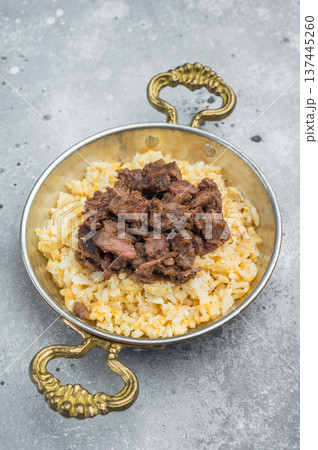 Kawurma qawurma layered over aromatic rice pilaf, highlighting seared protein fibers, granular structure and vintage culinary setup. Kawurma qawurma layered over aromatic rice pilaf, highlighting seared protein fibers, granular structure and vintage culinary setup. 137445260