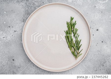 White empty plate with green rosemary garnish on neutral background. Modern food presentation with copy space White empty plate with green rosemary garnish on neutral background. Modern food presentation with copy space 137445262