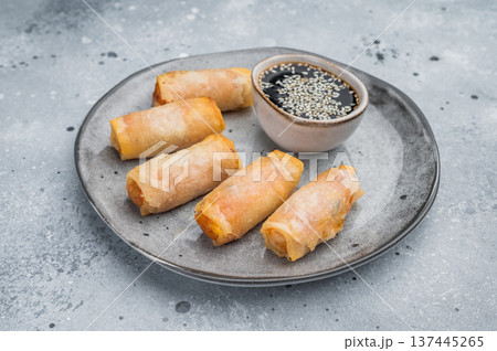 Crispy fried spring rolls served with soy dipping sauce and sesame seeds Asian appetizer flat lay on stone background Crispy fried spring rolls served with soy dipping sauce and sesame seeds Asian appetizer flat lay on stone background 137445265