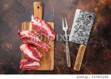 Raw beef short ribs portions with rich meat and bone structure on wooden board. Clean dark background for recipes and cuisine. 137445298