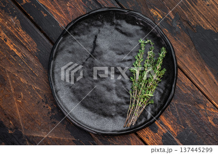 Empty ceramic plate with herbs on dark wood background. Rustic minimalist food mockup with copy space for menu and banners. Empty ceramic plate with herbs on dark wood background. Rustic minimalist food mockup with copy space for menu and banners. 137445299