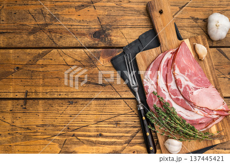 Traditional German schinken meat served with thyme and garlic on aged wood ideal for culinary photography. 137445421
