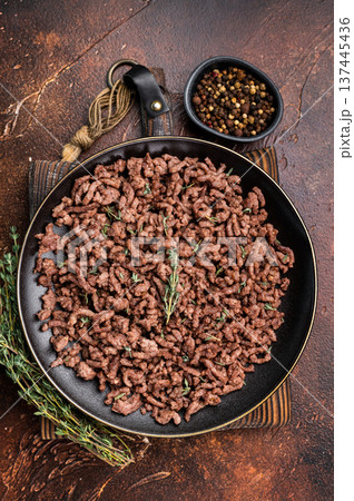 Fried mincemeat, cooked forcemeat in a plate. brown background. top view Fried mincemeat, cooked forcemeat in a plate. brown background. top view 137445436