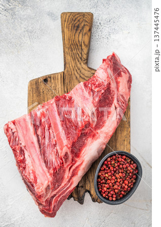 Uncooked beef ribs with fat and muscle texture on wooden board. Light background with copy space for food industry and recipes 137445476
