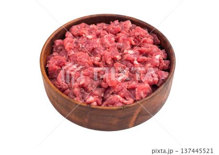 Raw chopped meat served in a wooden bowl over white surface perfect for recipe concepts culinary ads and protein rich food photography. 137445521