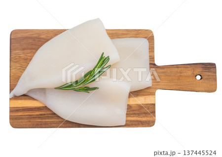 Fresh calamari tubes on a wooden board with rosemary on a bright white background perfect for seafood cuisine and cooking concepts. 137445524