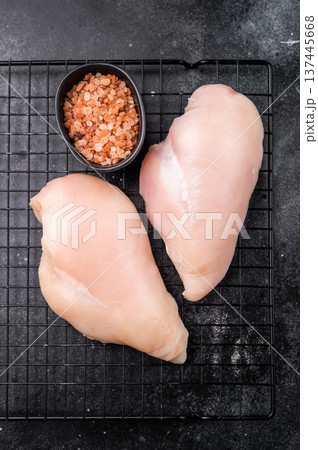 Fresh chicken breasts, beautifully displayed, showcasing their tender texture. Perfect for marinating and cooking your favorite dishes. black background. top view 137445668