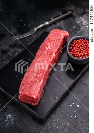 Exquisite raw wagyu beef, showcasing its rich marbling and vibrant color, perfect for gourmet dishes or high-end grilling experiences. black background. top view 137445686