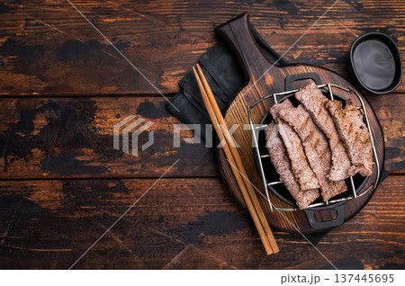 Flavorful yakiniku with juicy wagyu beef slices cooked right at the table. wooden background. top view 137445695