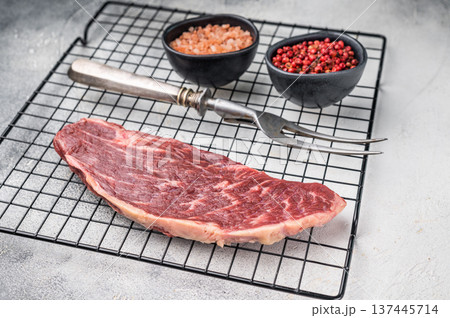 Fresh raw top sirloin steak, showcasing its rich color and marbling. grey background. top view 137445714