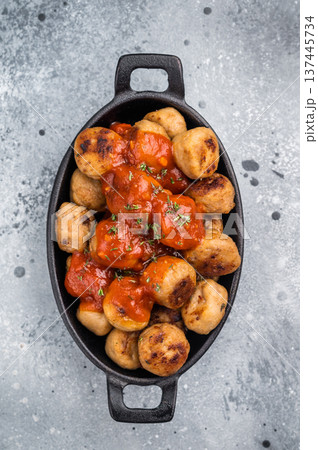 Roast meatballs served with tomato sauce. A classic comfort food in a skillet. grey background. top view 137445734
