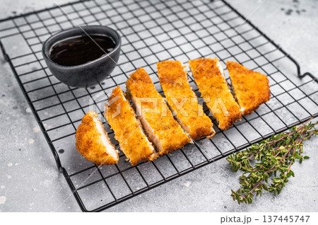 Tender chicken cutlet katsu, coated in crunchy breadcrumbs and fried to perfection. Ideal for a satisfying meal or as a topping for rice. grey background. top view 137445747