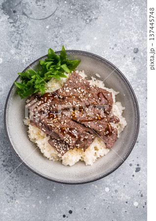 Delectable yakiniku feast, featuring a variety of marbled beef cuts and rice. A culinary journey that captures the essence of Japanese grilling traditions. grey background. top view 137445748