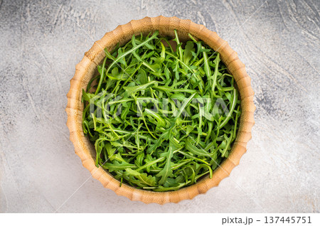 Fresh arugula leaves, vibrant and peppery, perfect for adding a zesty touch to salads and sandwiches. grey background. top view 137445751