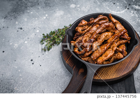 Delicious glazed teriyaki beef in a skillet. grey background. top view 137445756