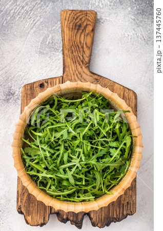 Fresh arugula leaves, vibrant and peppery, perfect for adding a zesty touch to salads and sandwiches. grey background. top view 137445760