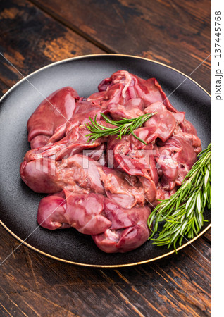 Raw chicken liver, featuring a glossy sheen and rich hue. A versatile ingredient that brings bold flavors to any culinary creation. wooden background. top view Raw chicken liver, featuring a glossy sheen and rich hue. A versatile ingredient that brings bold flavors to any culinary creation. wooden background. top view 137445768