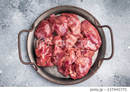 Raw poultry liver, chicken offals beautifully displayed, ready for seasoning. A nutritious ingredient ideal for gourmet dishes and traditional recipes. grey background. top view 137445775