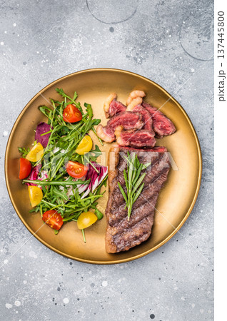 Grill Top Sirloin beef steak, rump steak with salad on a plate. grey background. top view Grill Top Sirloin beef steak, rump steak with salad on a plate. grey background. top view 137445800