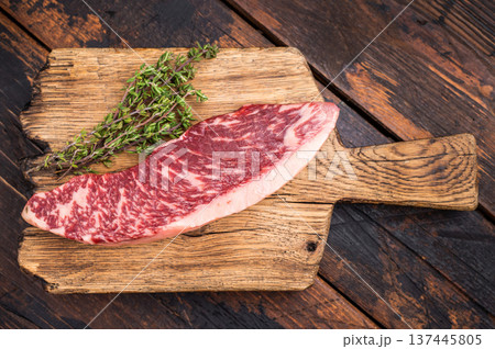 Fresh raw Brazilian picanha steak, beef meat, showcasing its rich marbling and vibrant color. wooden background. top view 137445805