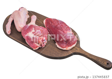 Fresh uncooked duck cuts on rustic wooden board against bright surface perfect for culinary preparation visuals and recipe content. 137445837