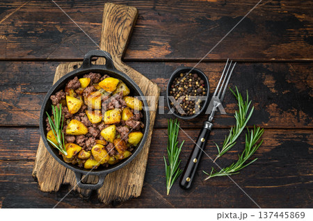 Rustic beef hash with fried potatoes served in a cast iron skillet on a wooden board perfect for comfort food and recipe visuals. Rustic beef hash with fried potatoes served in a cast iron skillet on a wooden board perfect for comfort food and recipe visuals. 137445869
